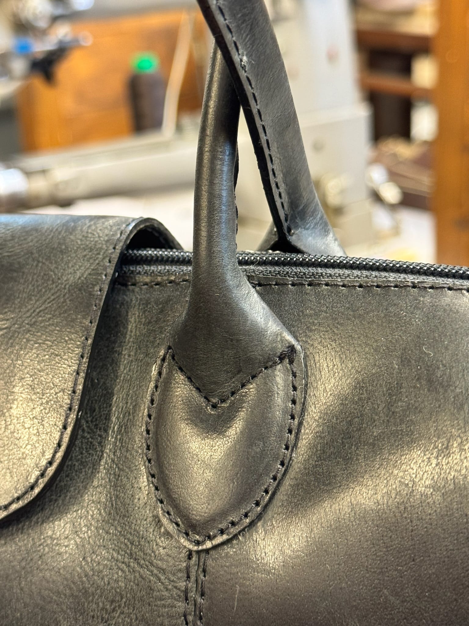 Handcrafted leather bag handle detail — saddle-stitched full-grain European leather by Old Continent Atelier artisan