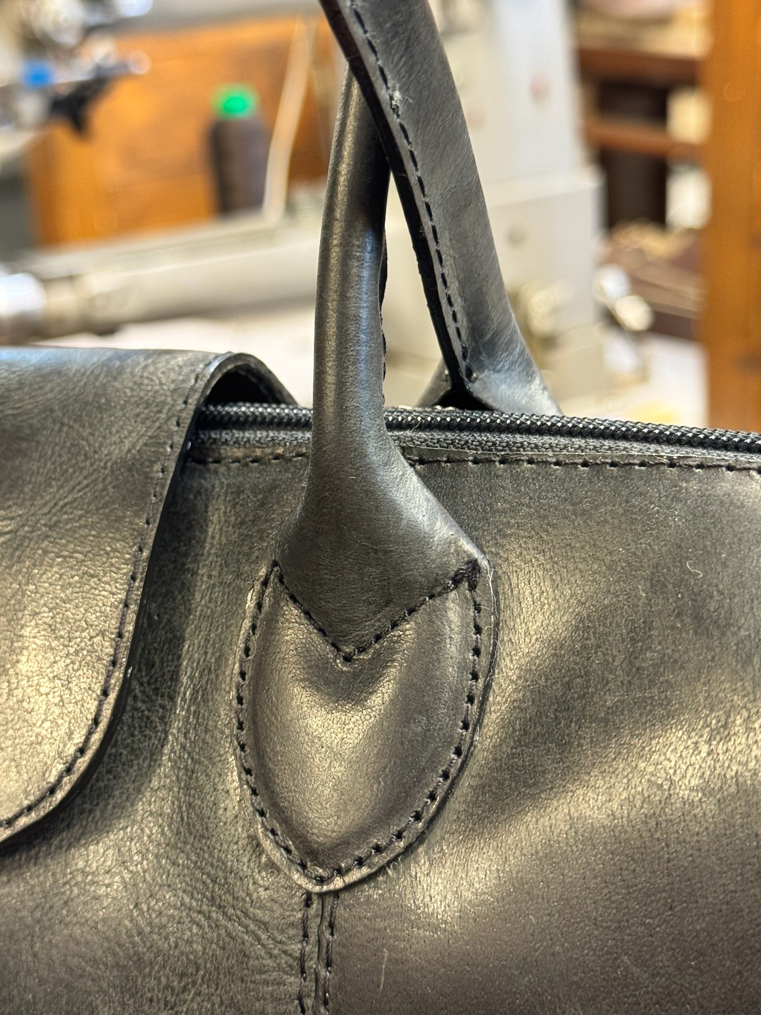 Handcrafted leather bag handle detail — saddle-stitched full-grain European leather by Old Continent Atelier artisan